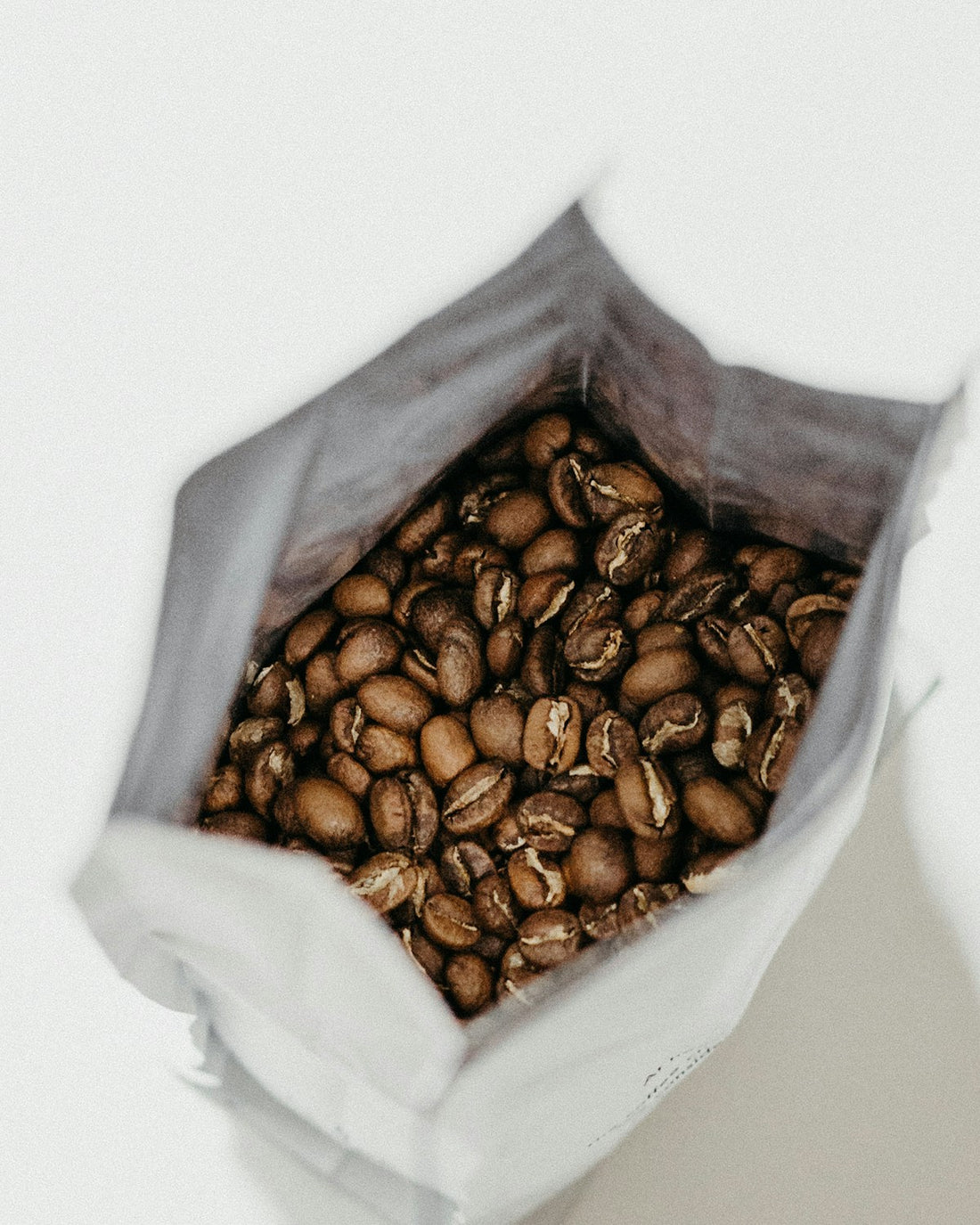 Sac de conservation ouvert rempli de grains de cafe torrefies vus de dessus