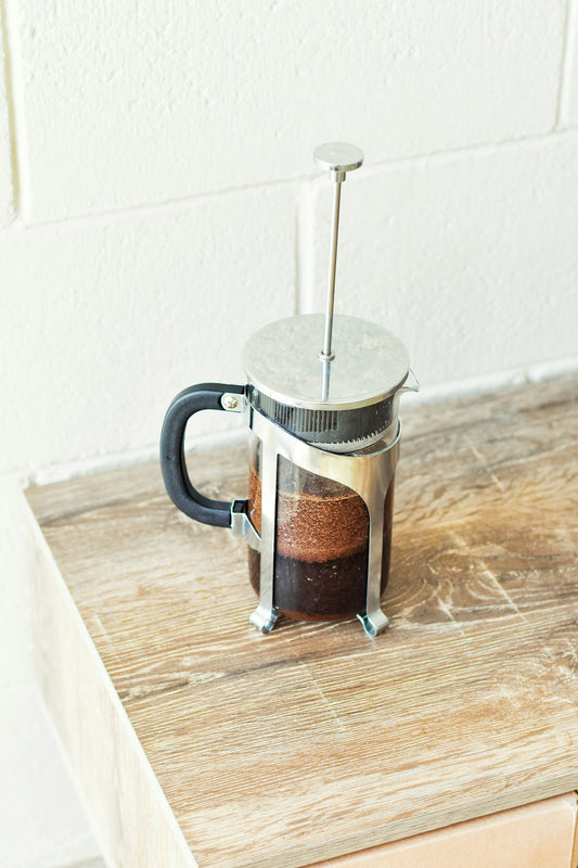 Cafetiere a piston French Press avec cafe infuse sur une table en bois